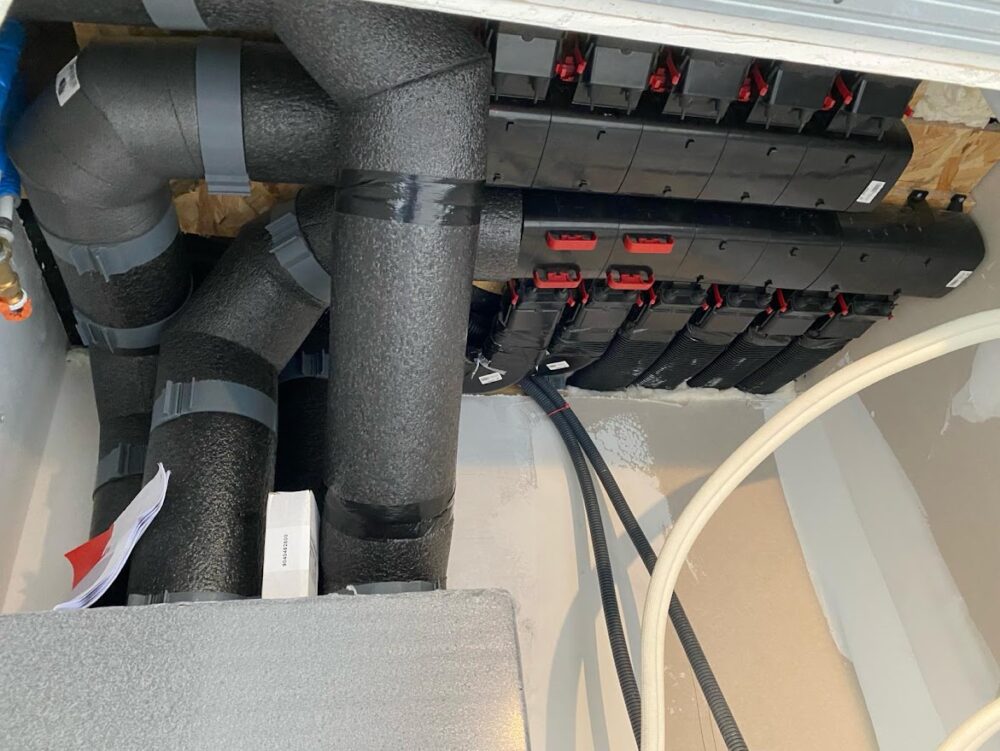 Aperçu du réseau de gaines isolées et des répartiteurs d'air d'une VMC double flux, assurant une distribution homogène et efficace de l'air ventilé.