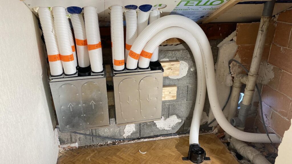 Caissons de répartition d’air d’une VMC double flux avec conduits flexibles isolés.