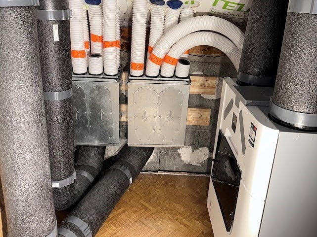 Installation d’un système de VMC double flux avec gaines isolées et caissons de répartition d’air.