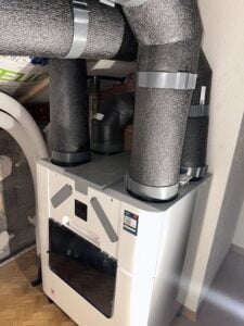 Système de ventilation VMC double flux installé dans une maison avec isolation thermique des conduits.