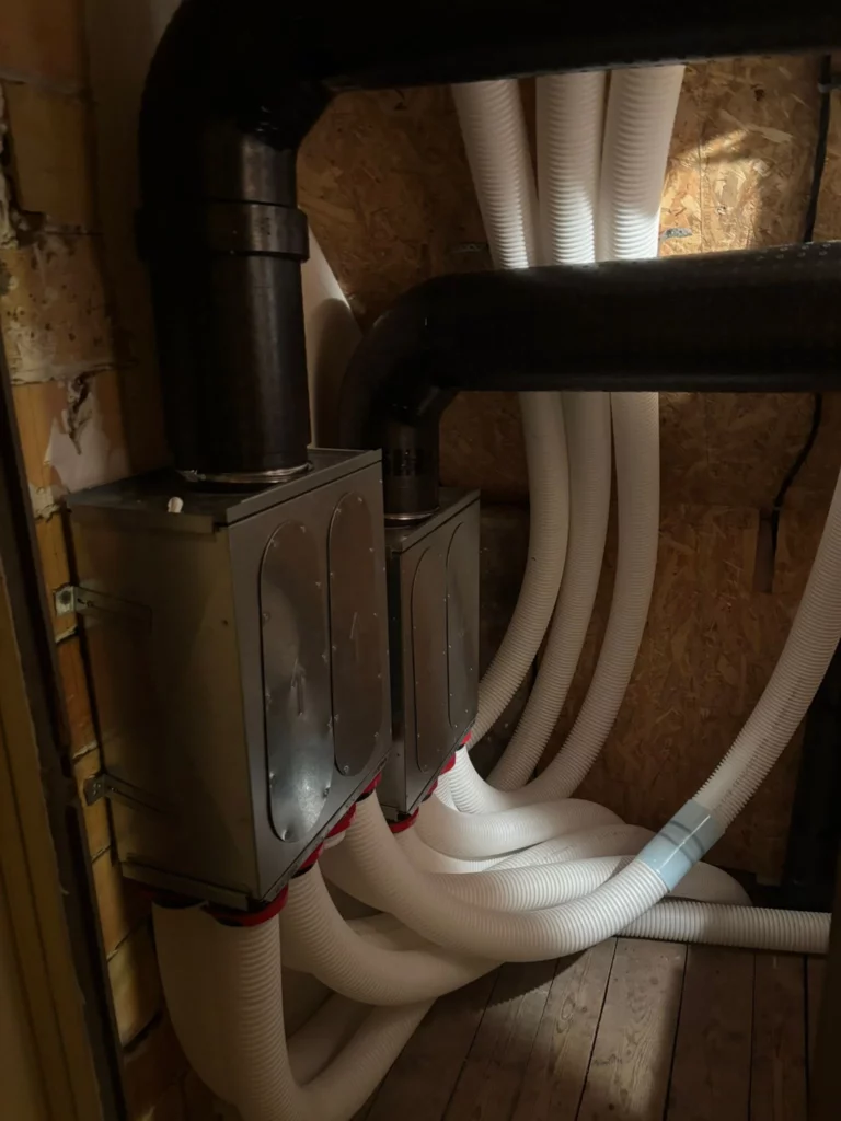 Collecteurs métalliques et gaines PEHD blanches pour une installation VMC double flux à Thonon-les-Bains.