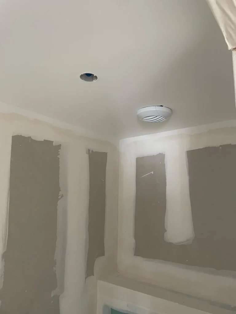 Bouche d'extraction d'une installation VMC simple flux S&P hygroréglable à Lullin dans un plafond en cours de finition.