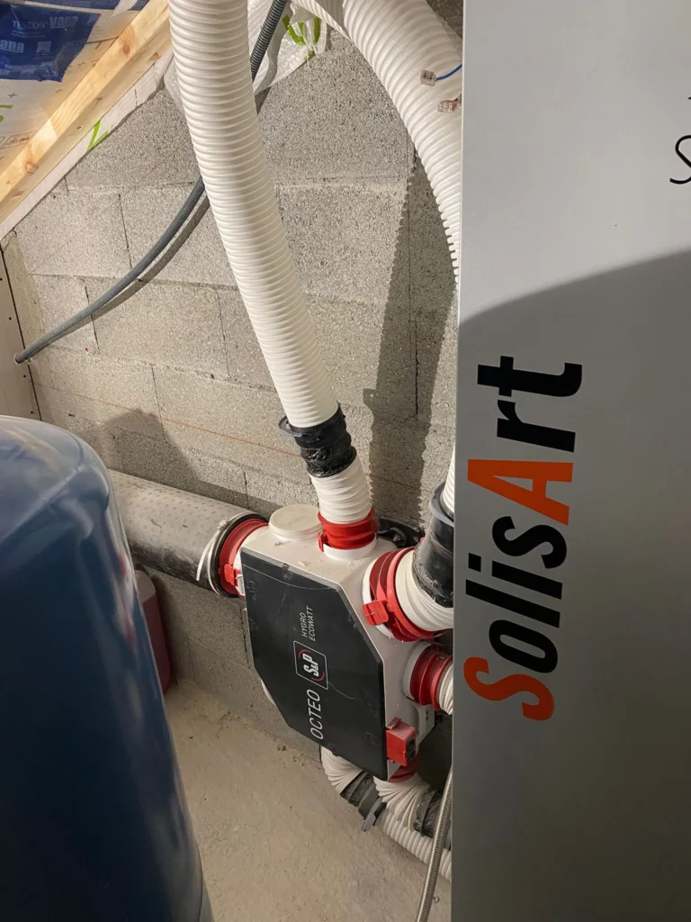 Caisson Octeo S&P d'une installation VMC simple flux hygroréglable posé sur un mur en parpaings à Lullin.