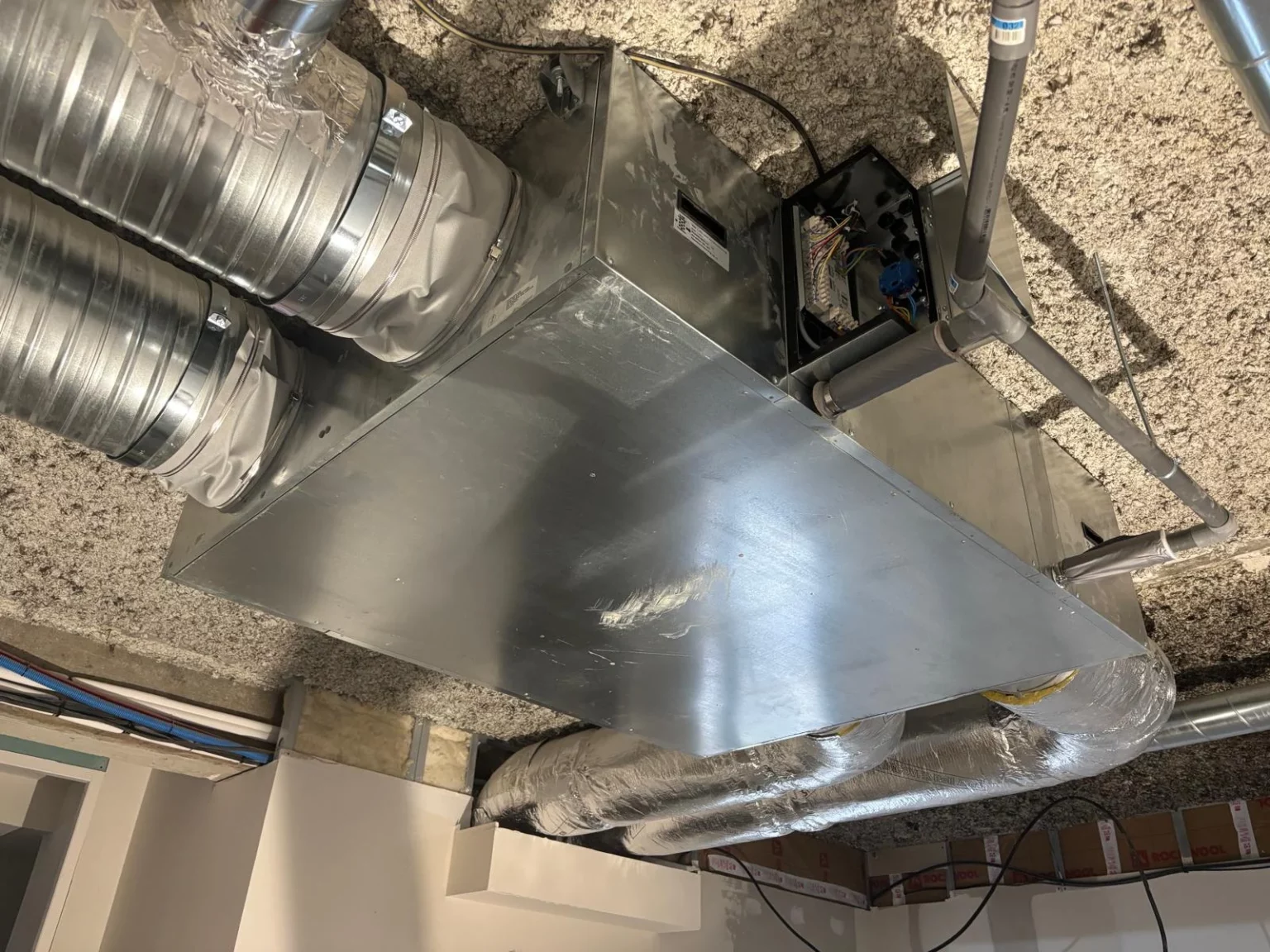 Raccordements électriques et hydrauliques d'une VMC double-flux dans une crèche à Evian.