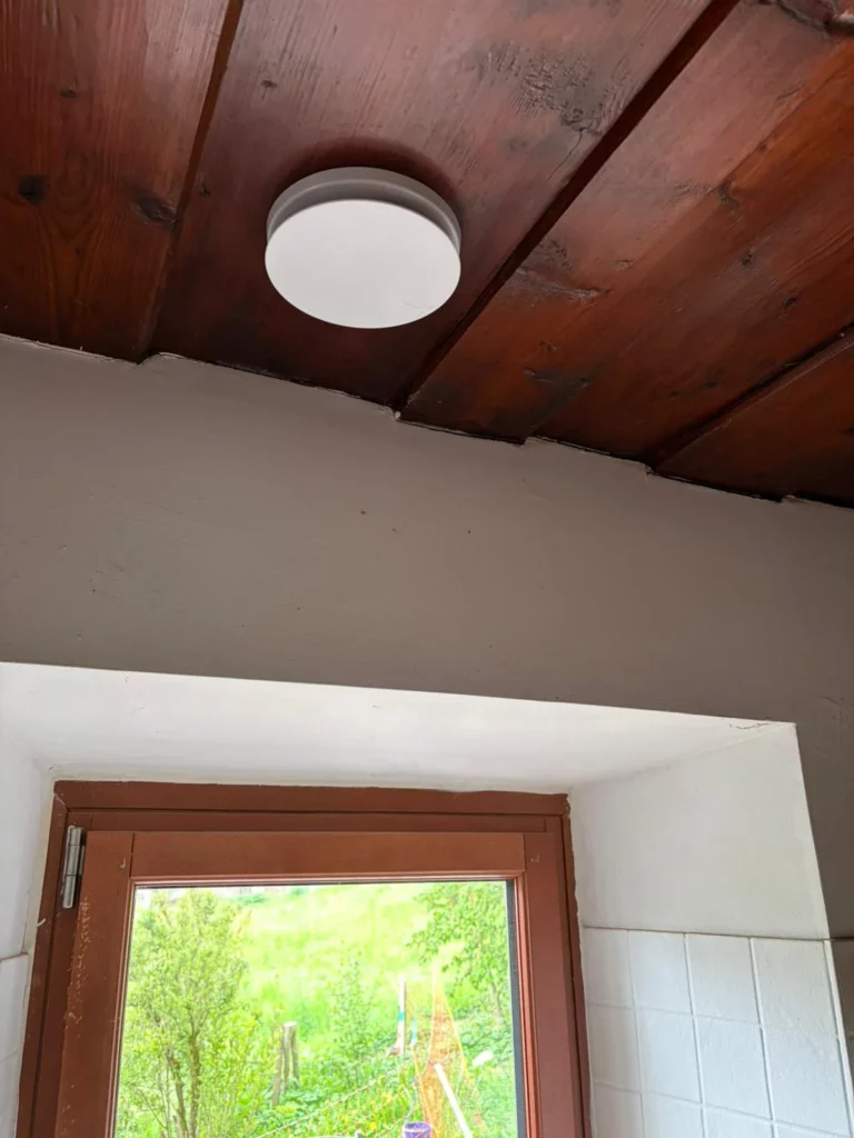 Bouche de soufflage VMC double flux encastrée dans un plafond en bois ancien à Vacheresse