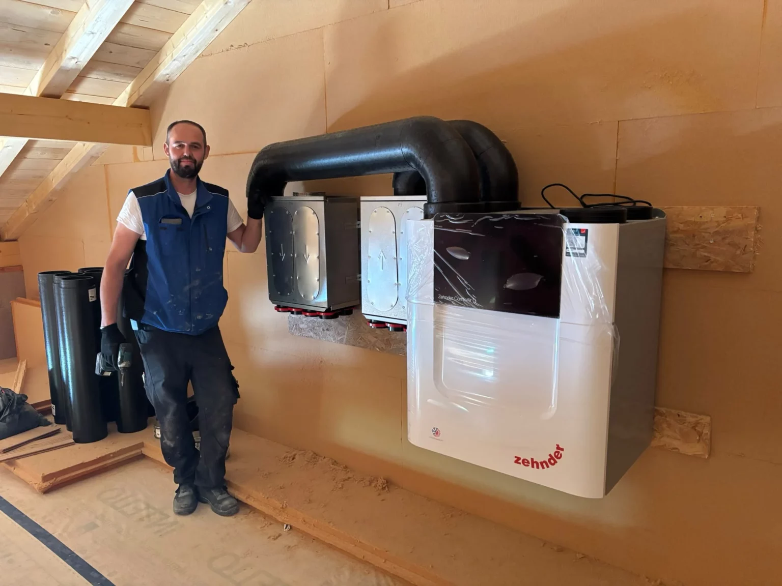 Technicien lors de l'installation d'une VMC double-flux Zehnder dans une maison neuve à Peillonnex